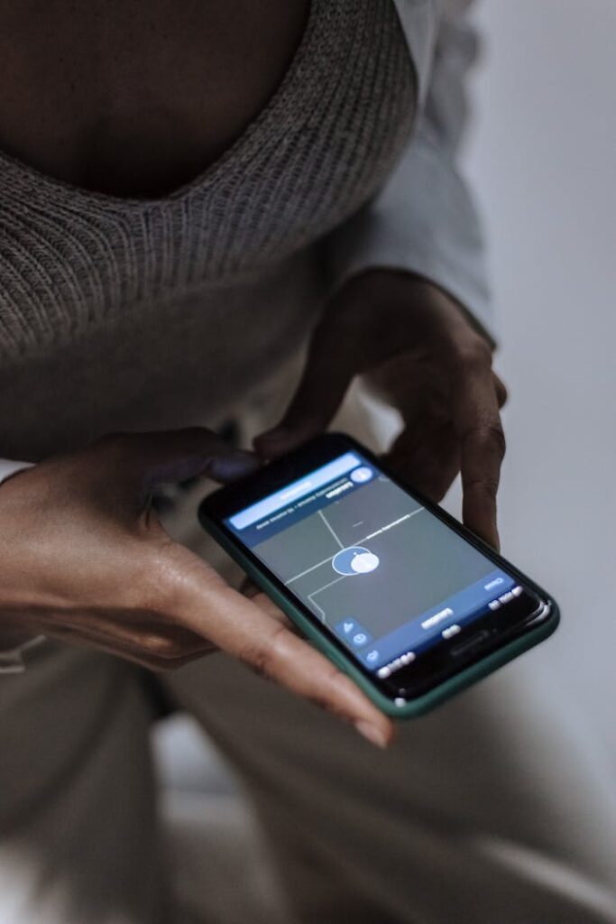 Close-up of a woman holding a smartphone with GPS navigation displayed, emphasizing technology and connectivity.